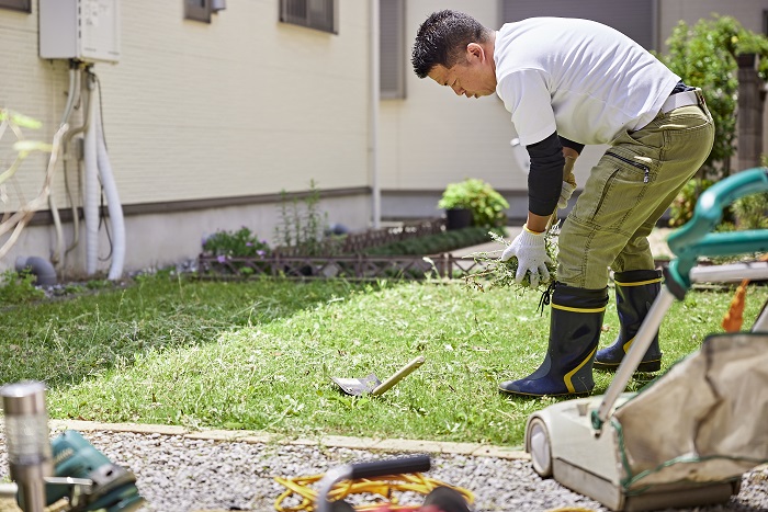庭で草を集める作業